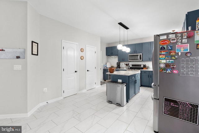 kitchen featuring appliances with stainless steel finishes, blue cabinetry, decorative light fixtures, decorative backsplash, and a center island