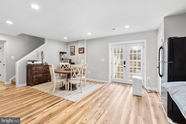 dining space with light hardwood / wood-style flooring and french doors