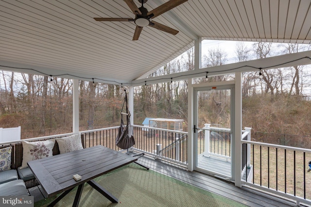 unfurnished sunroom featuring ceiling fan and lofted ceiling with beams