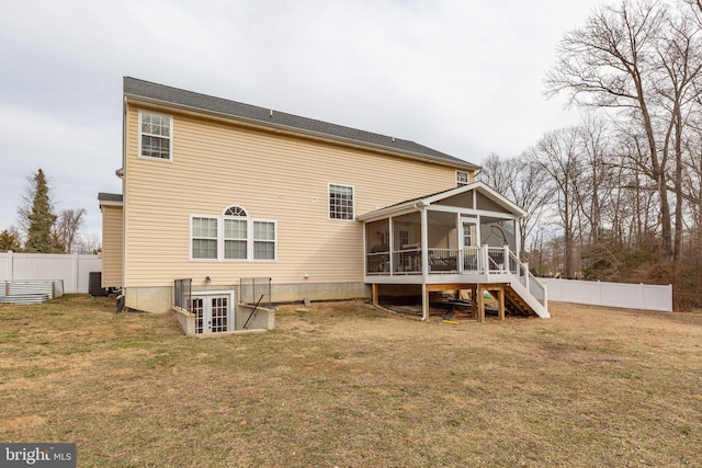 back of house featuring a yard and a sunroom