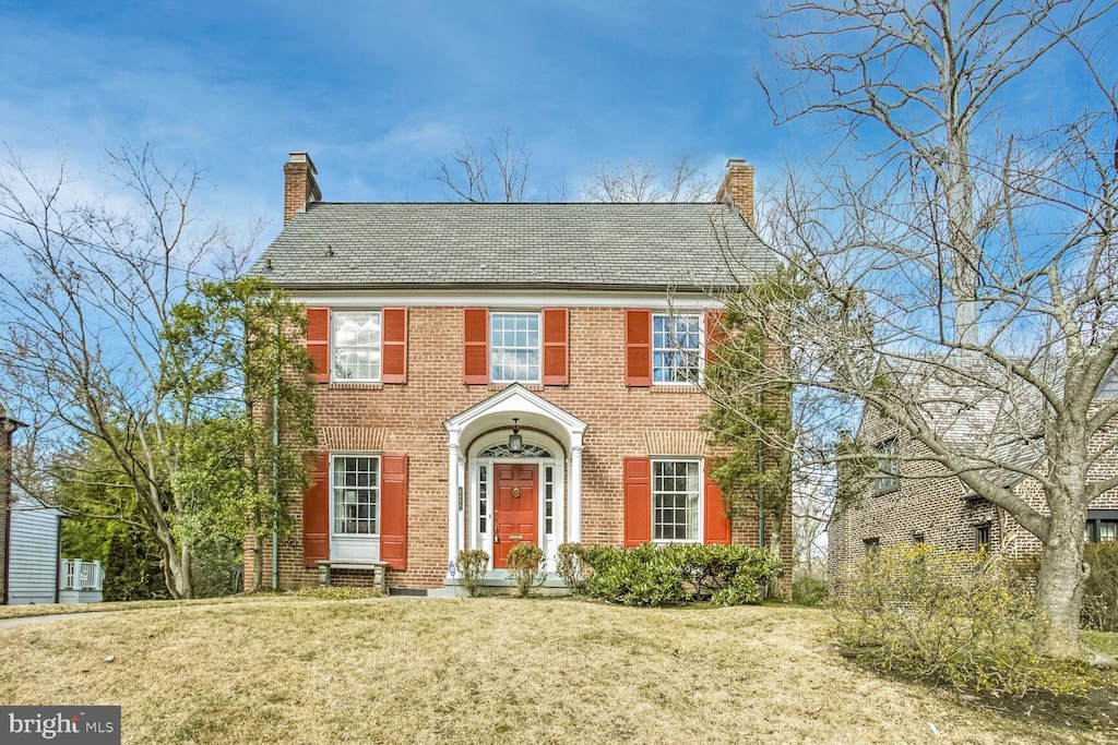 colonial home with a front lawn