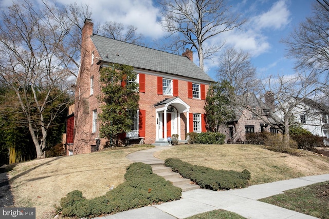 colonial home featuring a front lawn