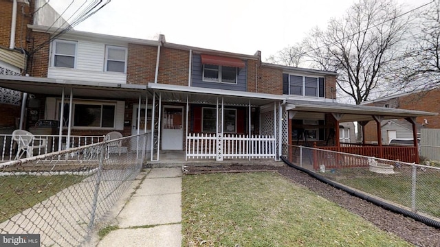 view of property featuring a porch and a front lawn