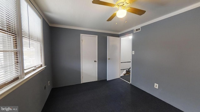 unfurnished bedroom with ornamental molding, carpet, ceiling fan, and a closet