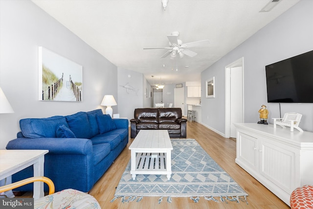 living room featuring light hardwood / wood-style floors and ceiling fan