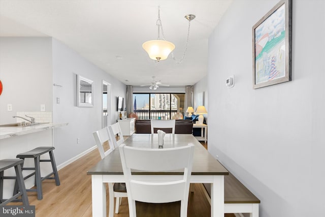 dining area with sink and light hardwood / wood-style floors