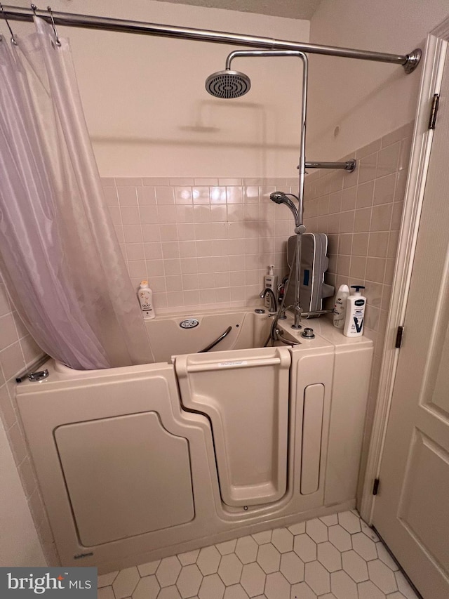 bathroom featuring tile patterned flooring and tile walls