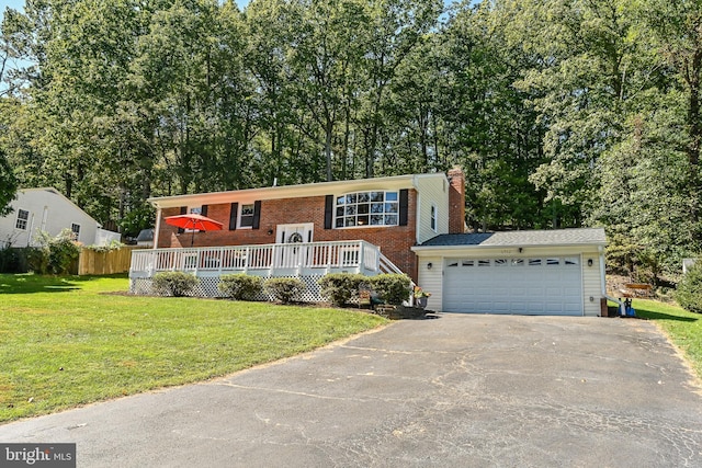 split foyer home featuring a wooden deck, a garage, and a front lawn