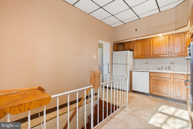 kitchen with white appliances, sink, and a paneled ceiling