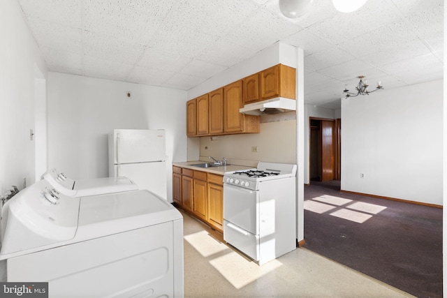 kitchen featuring sink, a paneled ceiling, washing machine and clothes dryer, and white appliances