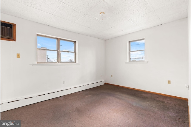 spare room featuring a baseboard heating unit and a wall mounted air conditioner