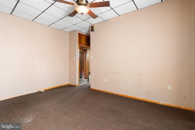 unfurnished room with dark colored carpet, a paneled ceiling, and ceiling fan