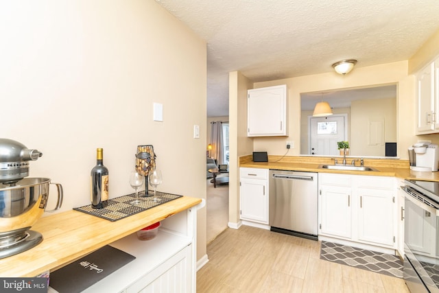 kitchen with white cabinetry, appliances with stainless steel finishes, sink, and wood counters