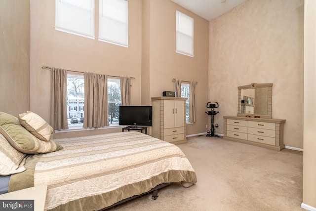 carpeted bedroom with a towering ceiling