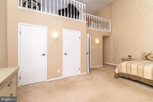 carpeted bedroom featuring a towering ceiling