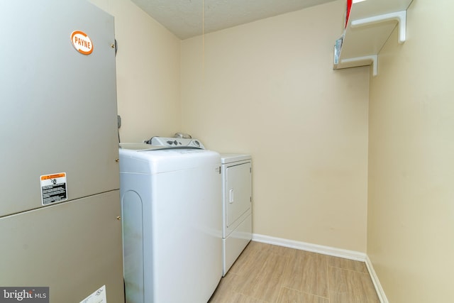 laundry room featuring washer and dryer, heating unit, and a textured ceiling