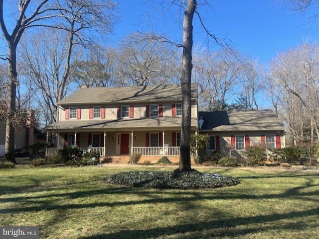 colonial inspired home featuring covered porch and a front lawn