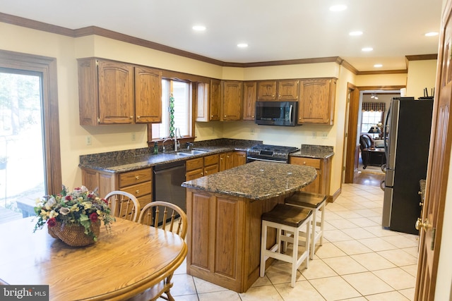 kitchen featuring sink, a breakfast bar area, light tile patterned floors, a kitchen island, and stainless steel appliances