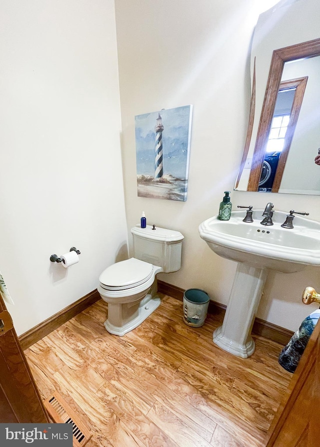 bathroom with hardwood / wood-style flooring, toilet, and sink