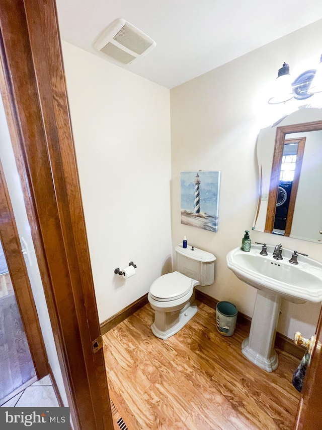 bathroom with wood-type flooring, sink, and toilet