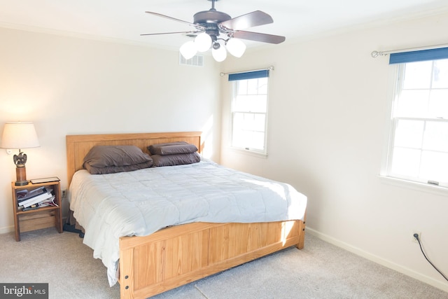 bedroom featuring light carpet, multiple windows, ornamental molding, and ceiling fan