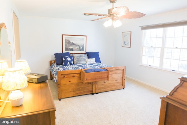 bedroom featuring light carpet, ornamental molding, and ceiling fan