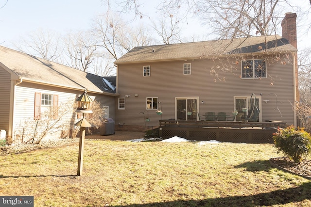 rear view of property featuring a lawn and a deck