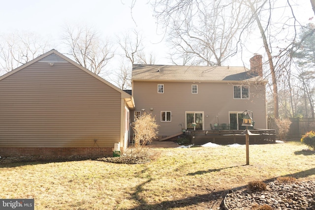 back of house featuring a wooden deck and a lawn