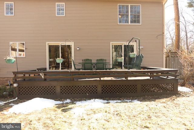 snow covered rear of property featuring a deck