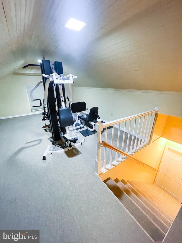 workout area with vaulted ceiling and carpet