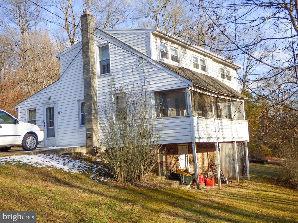 exterior space featuring a sunroom and a front lawn