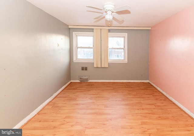 empty room with ceiling fan and light hardwood / wood-style flooring