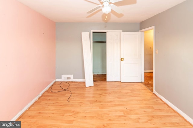 unfurnished bedroom with light wood-type flooring, ceiling fan, and a closet