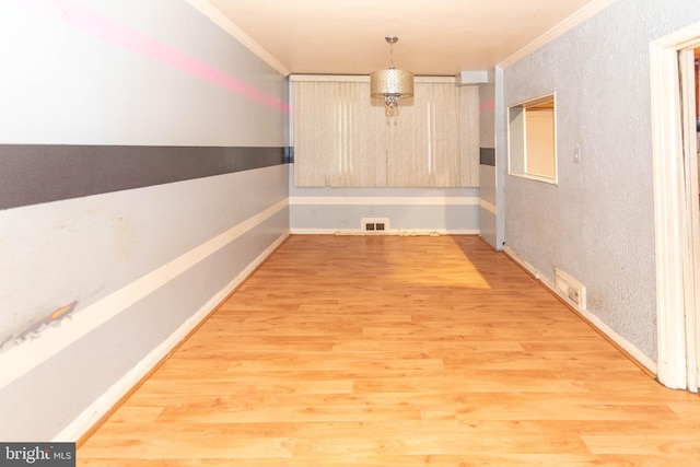 unfurnished dining area with crown molding and hardwood / wood-style floors