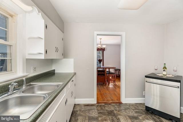 kitchen with sink, refrigerator, a notable chandelier, white cabinets, and decorative backsplash