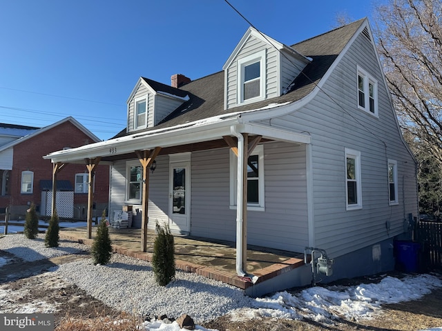 cape cod-style house with covered porch