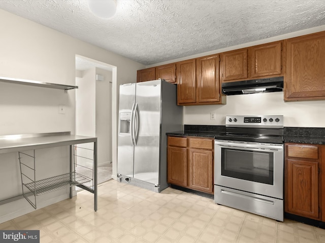 kitchen featuring under cabinet range hood, stainless steel appliances, brown cabinetry, dark countertops, and light floors