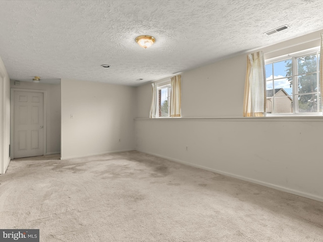 empty room featuring carpet flooring, baseboards, and a textured ceiling