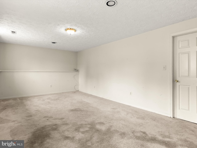 carpeted empty room with a textured ceiling and baseboards