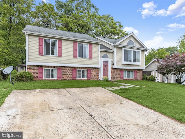 raised ranch with brick siding and a front lawn
