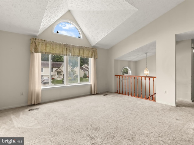 unfurnished room with carpet floors, a textured ceiling, baseboards, and high vaulted ceiling