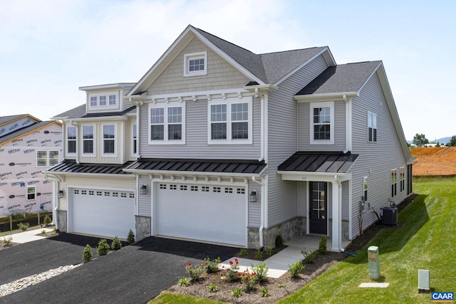 view of front of home with a garage, a front lawn, and central air condition unit