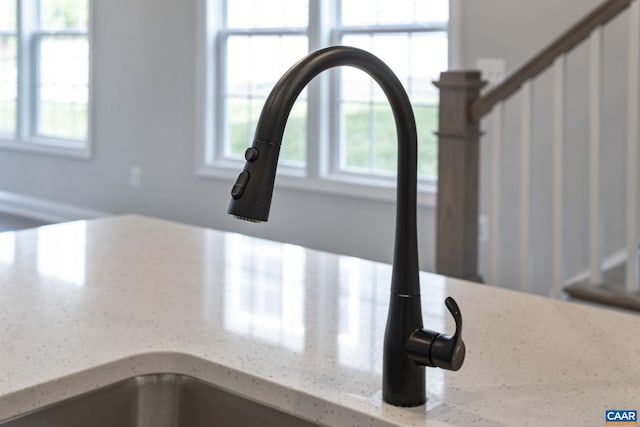 details featuring light stone countertops and sink