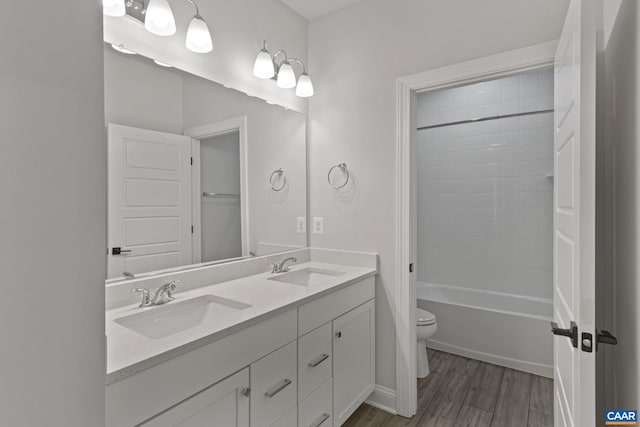 full bathroom with wood-type flooring, toilet, bathing tub / shower combination, and vanity