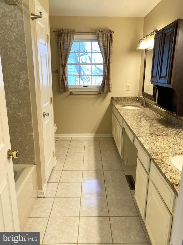 bathroom featuring vanity, toilet, tile patterned flooring, and a bath