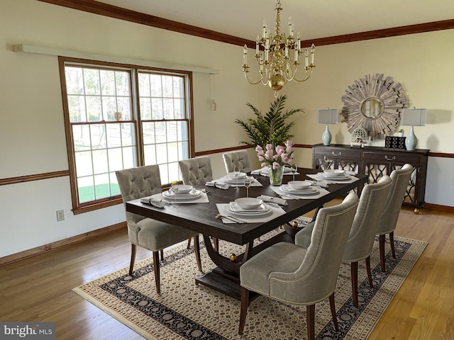 dining area featuring crown molding, hardwood / wood-style floors, and a chandelier