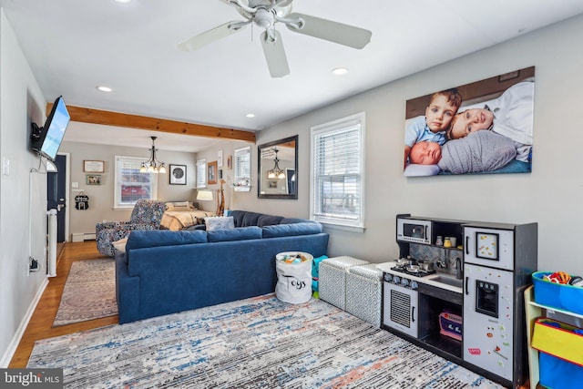 living room with ceiling fan, a baseboard heating unit, hardwood / wood-style floors, and beam ceiling