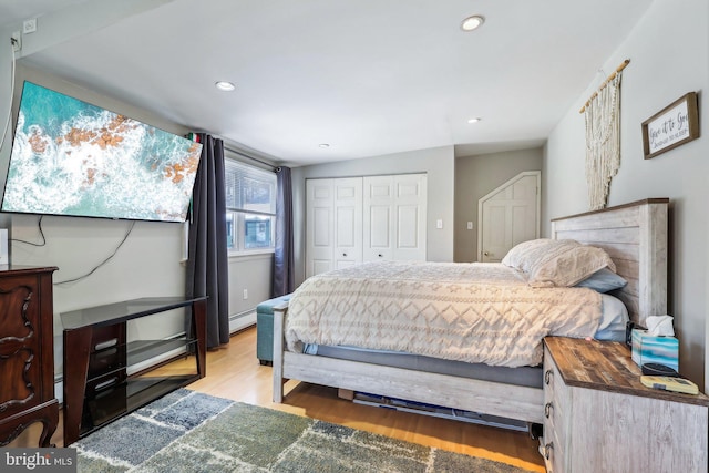 bedroom featuring baseboard heating, a closet, and light wood-type flooring