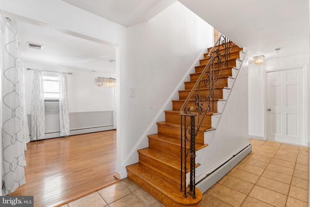 stairs with tile patterned flooring and baseboard heating