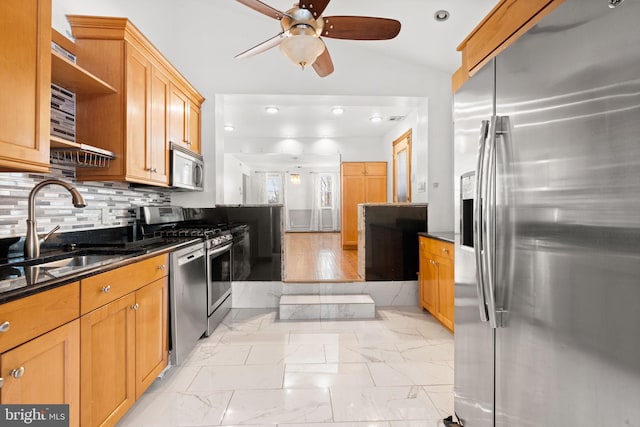 kitchen featuring lofted ceiling, sink, dark stone countertops, backsplash, and stainless steel appliances